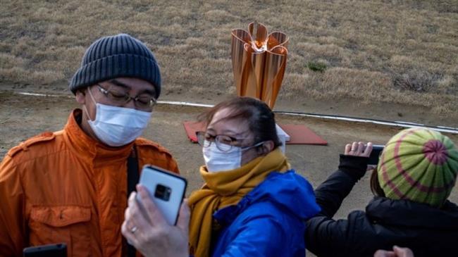 Thousands flock to see Olympic flame in Japan despite virus fears